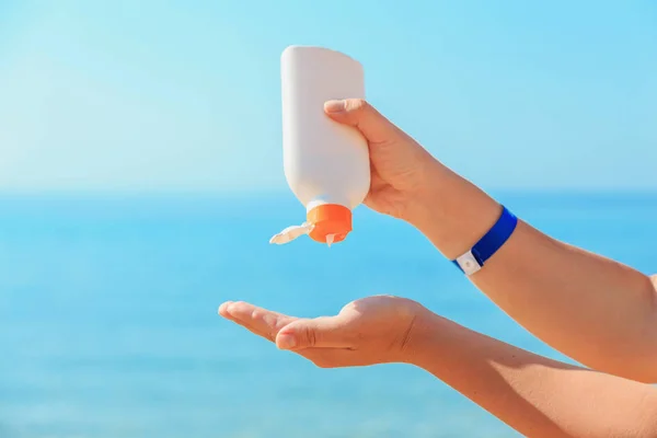 Women's hands apply a suntan lotion to the skin. — Stock Photo, Image