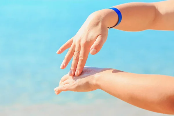 Жіночі руки наносять лосьйон для засмаги на шкіру . — стокове фото
