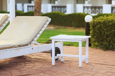 şezlong yakınındaki küçük beyaz masa