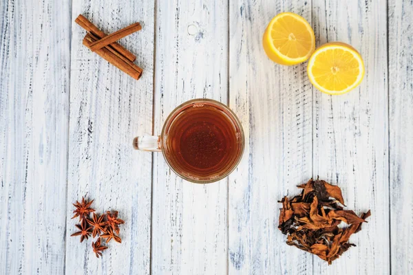 Tasse de thé, citron, cannelle, clous de girofle, feuilles de thé séchées — Photo