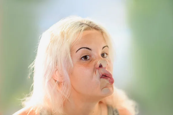 Vrouwelijke gezicht gedrukt tegen glas of venster — Stockfoto