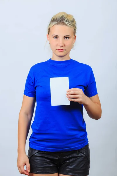 Young blonde girl holds leaflet with copyspace — Stock Photo, Image