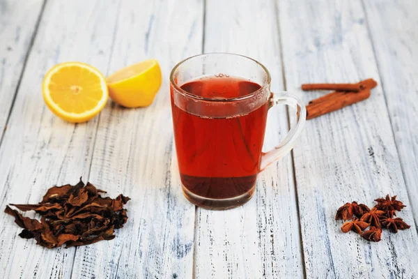 Tè caldo, bastoncini di cannella, anice stellato, foglie di tè essiccate e arancia — Foto Stock