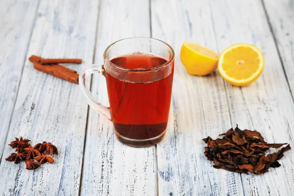 Tè caldo, bastoncini di cannella, anice stellato, foglie di tè essiccate e arancia — Foto Stock