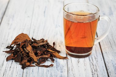 Fincan siyah çay ve çay yaprakları