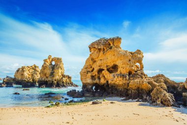 Güneşli bir gün mavi okyanusta kayalarda