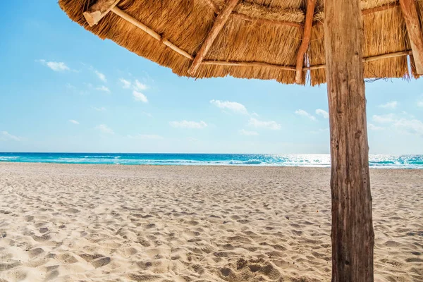 Sazdan güneş şemsiyesi altında sahilde görünümü