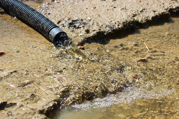 Primo piano d'acqua che fluisce da un'estremità di tubo flessibile — Foto Stock