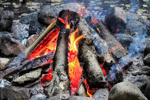 Smoke drifting out of a tepee campfire