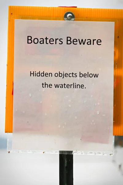 A boaters beware hidden object under water sign.