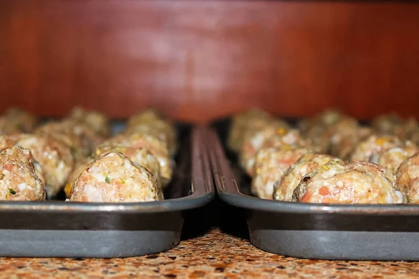 Weergave van ruwe Turkije pijnboomnoot gehaktballen op cookie vellen — Stockfoto