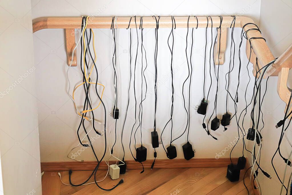 Numerous cables hang from a stair rail