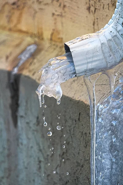 Ice melting though an eavestrough in spring — Stock Photo, Image