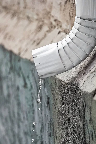 Water flowing out the end of an eavestrough — Stock Photo, Image