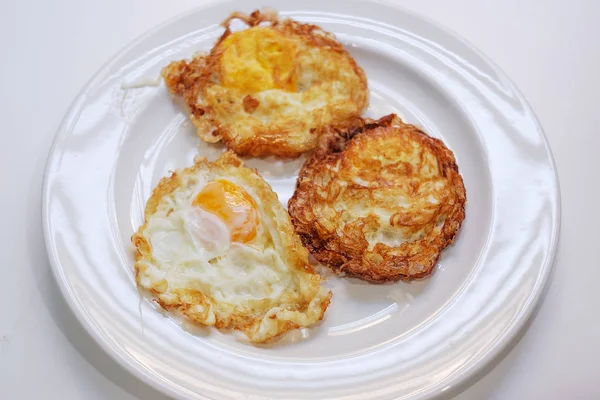 Três ovos fritos em placa branca e foco seletivo — Fotografia de Stock
