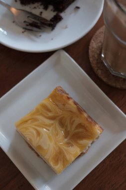 Limonlu cheesecake woodent tablo ve seçici odak beyaz plaka üzerinde