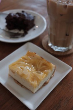 Limonlu cheesecake woodent tablo ve seçici odak beyaz plaka üzerinde