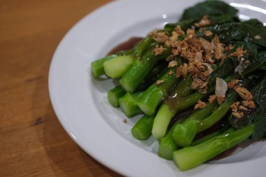 heyecan Çince lahana (Çin brokoli) Beyaz plaka ve seçici odak istiridye soslu kızarmış
