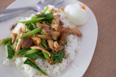 bir yumurta ve pişirme pirinç ile kızarmış kutsal fesleğen tavuk dilim karıştırın