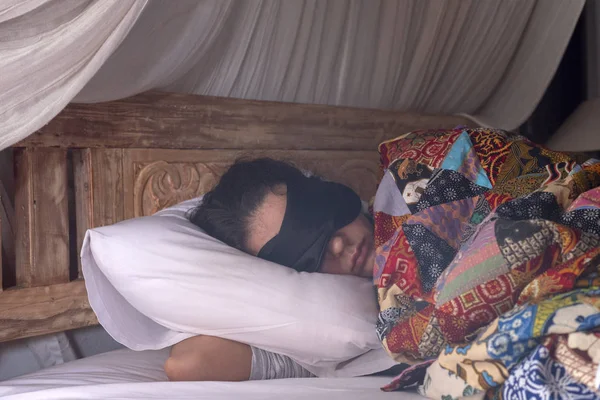 Женщина спит в маске под лоскутным одеялом . — стоковое фото