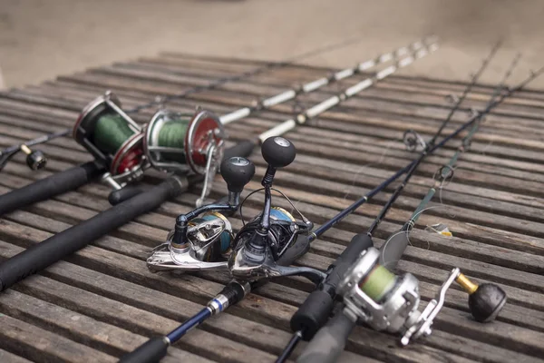 Fishing rods, spinning rods with fishing line on a wooden background in the morning light. Fishing.