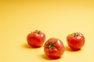 Sarı arka planda kırmızı domatesler