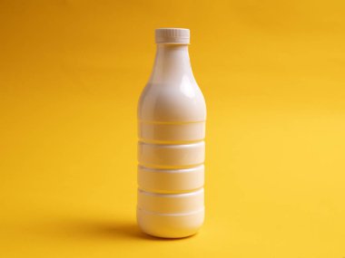 Sarı arka planda süt veya kefir şişesi