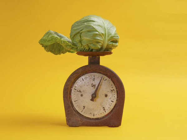 капуста на весах на желтом фоне
