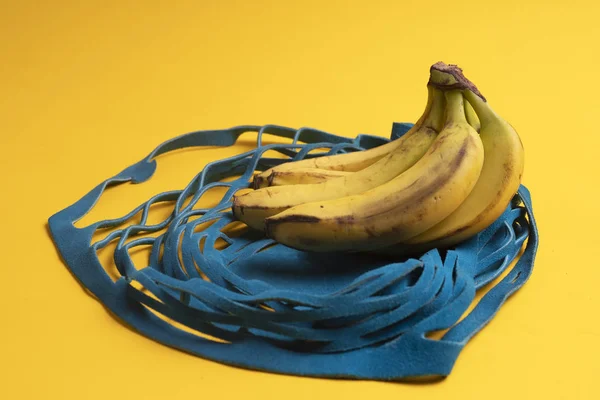 bananas in a shopping bag on a yellow background