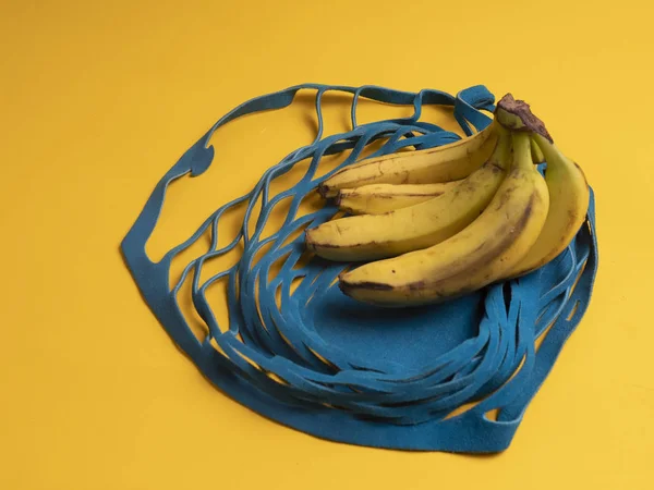 bananas in a shopping bag on a yellow background