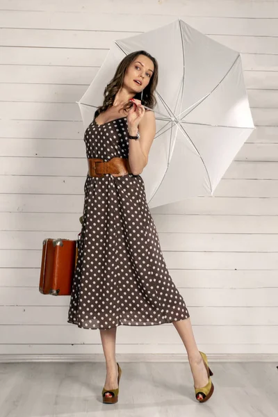 Dziewczyna w polka-dot sukienka z retro walizka i parasol. Mary Poppins styl. — Zdjęcie stockowe