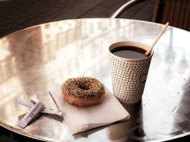 Açık kafede bir masada kahve ve donut