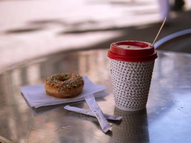 Açık kafede bir masada kahve ve donut