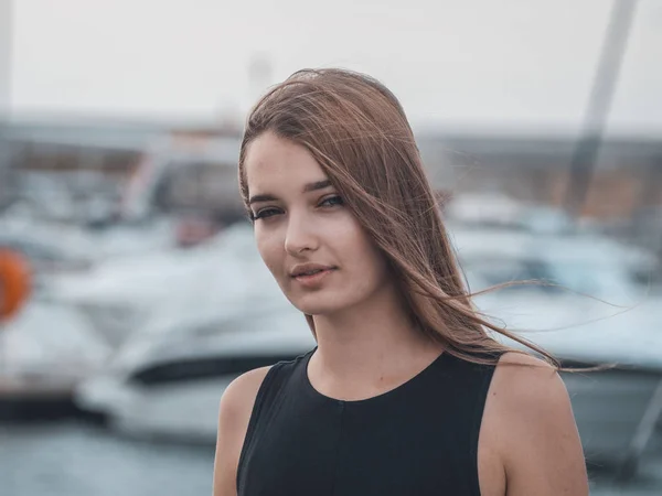 Retrato de una joven hermosa mujer con el pelo volando sobre fondo borroso marina. Vacaciones de verano . —  Fotos de Stock