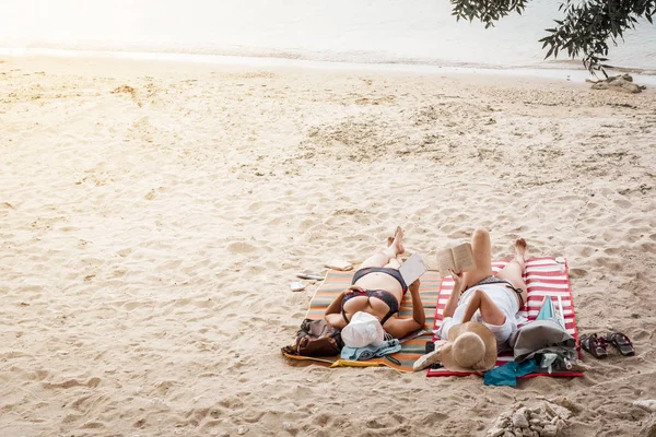 Volwassen vrouwen ontspannen op het strand en boeken lezen — Stockfoto