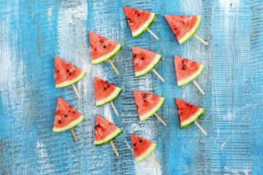 Mavi ahşap arka plan üzerinde karpuz üçgen dilimleri.