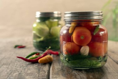 Bir kavanozda koruma, turşu, salatalık ve domates