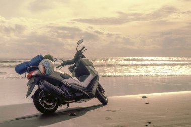 Denizin arka planda kamp ekipmanları ile Motosiklet. Yer plajı. Seyahat