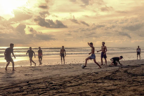 Indonesia, Pasut, 1 de febrero de 2019. Los hombres juegan al fútbol en la playa al atardecer — Foto de Stock