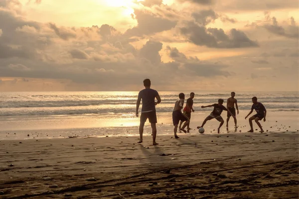 Indonesia, Pasut, 1 de febrero de 2019. Los hombres juegan al fútbol en la playa al atardecer — Foto de Stock