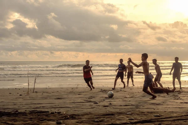 Indonesia, Pasut, February 1, 2019. Men play football on the beach at sunset time — Stock Photo, Image