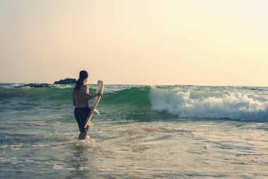 sörf tahtası olan adam okyanusa gidiyor