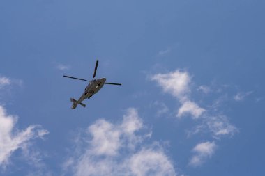 Mavi gökyüzünde uçan helikopter.