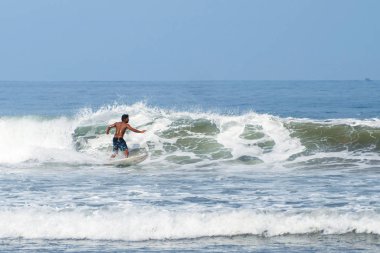 Endonezya, Bali, 4 Nisan 2019 Sörfçü dalga. Sörfçü boruyu bırakıyor. Bali adasında dalgalar. Sudan alınmış. Sörfçü dalga yakalar
