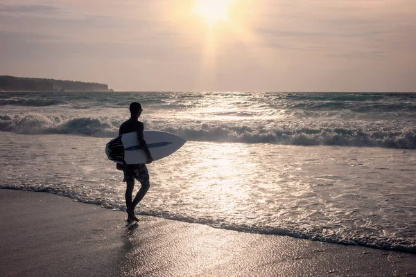 Hombre con una tabla de surf entra en el océano — Foto de Stock