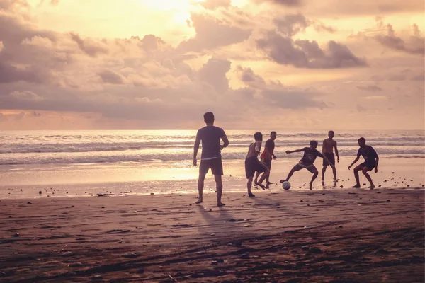 Indonesië, Pasut, 1 februari 2019. Mannen spelen voetbal op het strand bij zonsondergang — Stockfoto