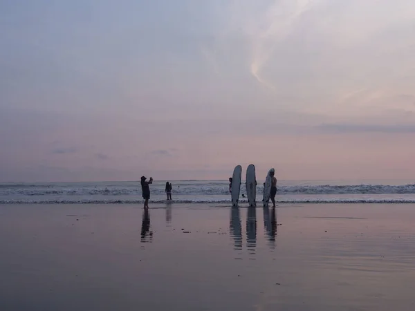 Indonesië, Bali, april 4, 2019 een familie op een Surfboard strand wordt gefotografeerd bij zonsondergang aan zee — Stockfoto
