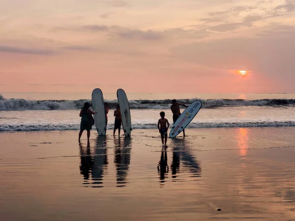 Indonesia, Bali, 4 de abril de 2019 Una familia en una playa de tablas de surf es fotografiada al atardecer junto al mar — Foto de Stock