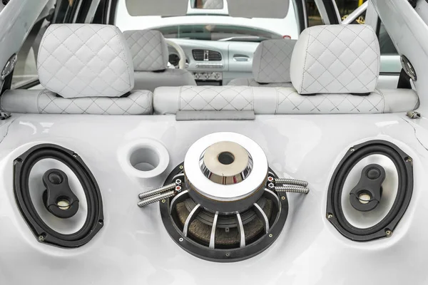 Aracın bagajında güçlü ses sistemi ve hoparlörleri olan akort edilmiş bir araba. Özel beyaz araba iç mimarisi.