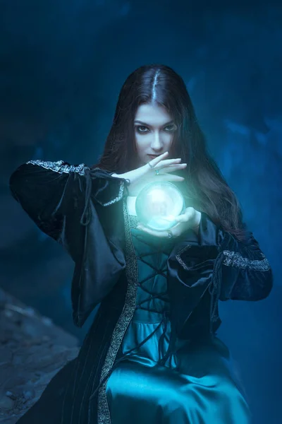 La bruja con bola mágica en sus manos causa un espíritu — Foto de Stock